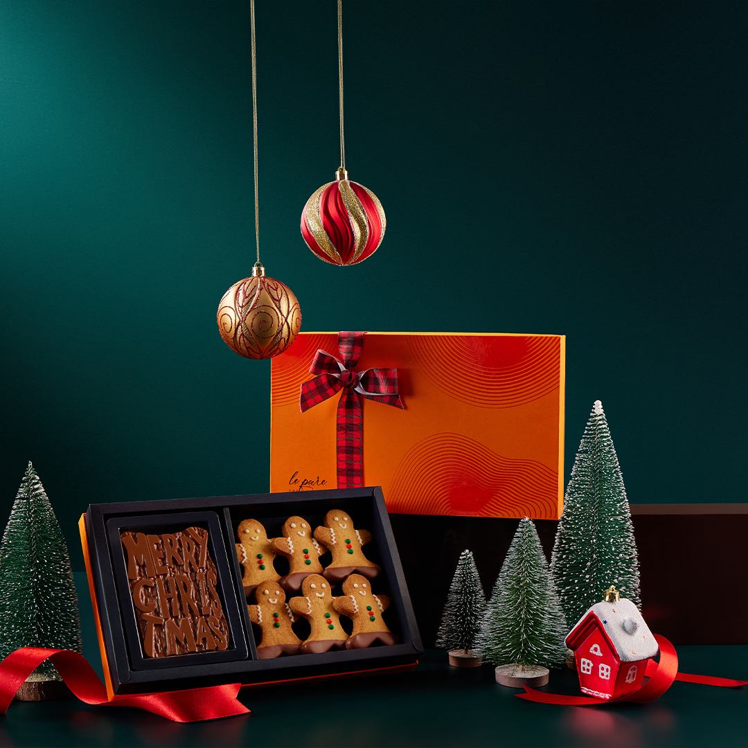 A Merry Christmas chocolate gift box with a walnut brownie fudge bar and gingerbread cookies.